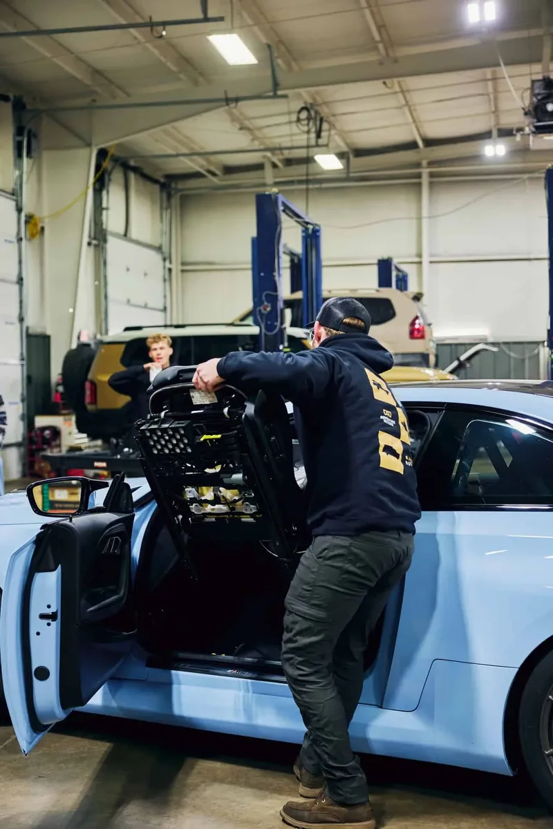 Technician at the open bonnet of a performance car